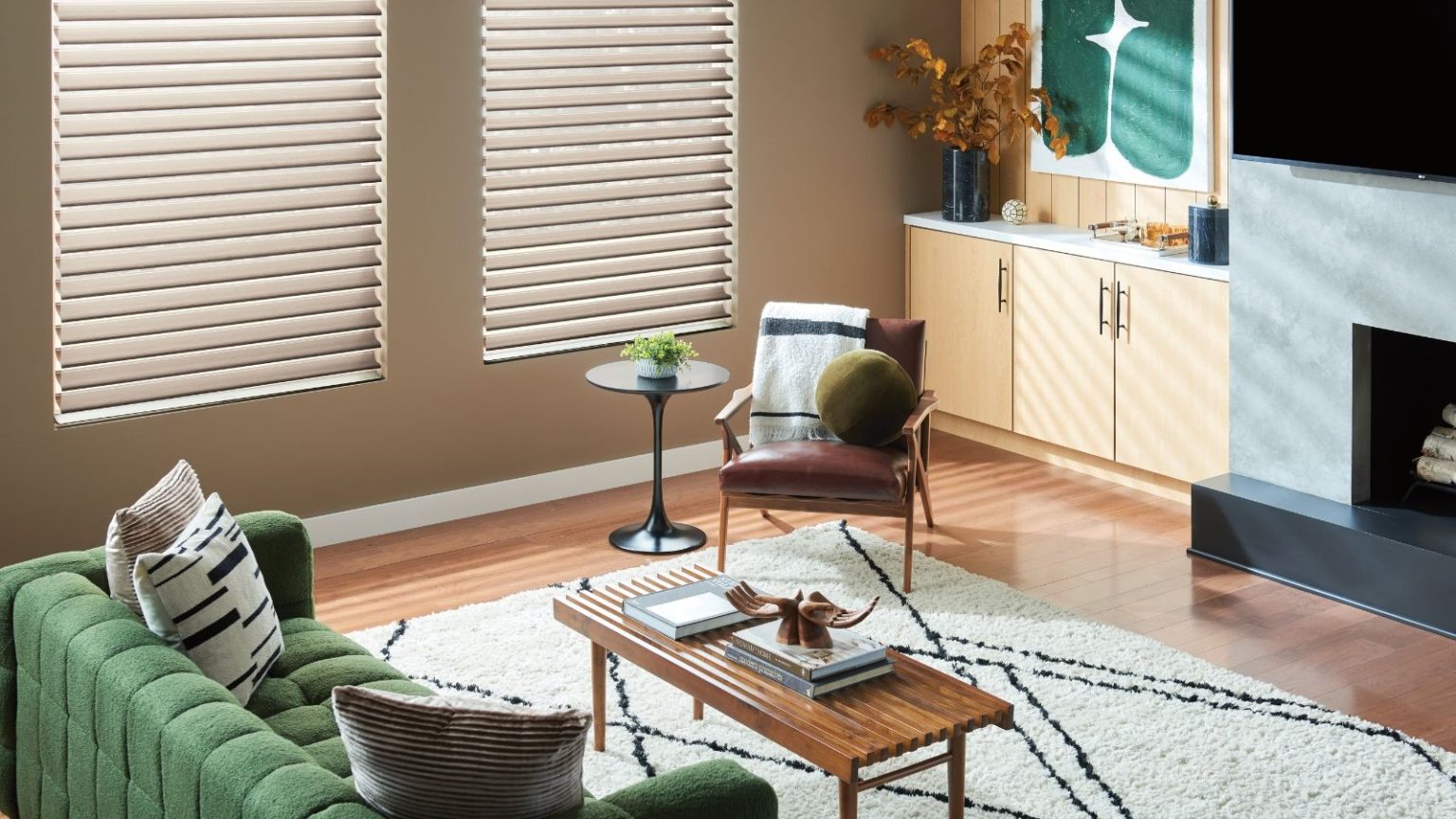 Si vous n’achetez qu’une seule chose ce Black Friday, offrez-lui cette barre de son Bose de 300 $ qui était impressionnante lors du test – elle rend les soirées cinéma de Noël magiques Colorful living room with green velvet sofa, wooden coffee table, black and white rug, brown armchair, two closed blinds, and wooden floors. A TV and fireplace is pictured to the right.