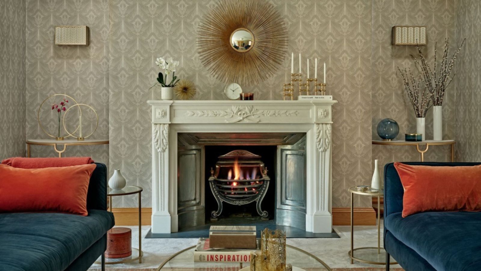 Cheminée confortable dans un salon recouvert de moquette avec sodas en velours bleu