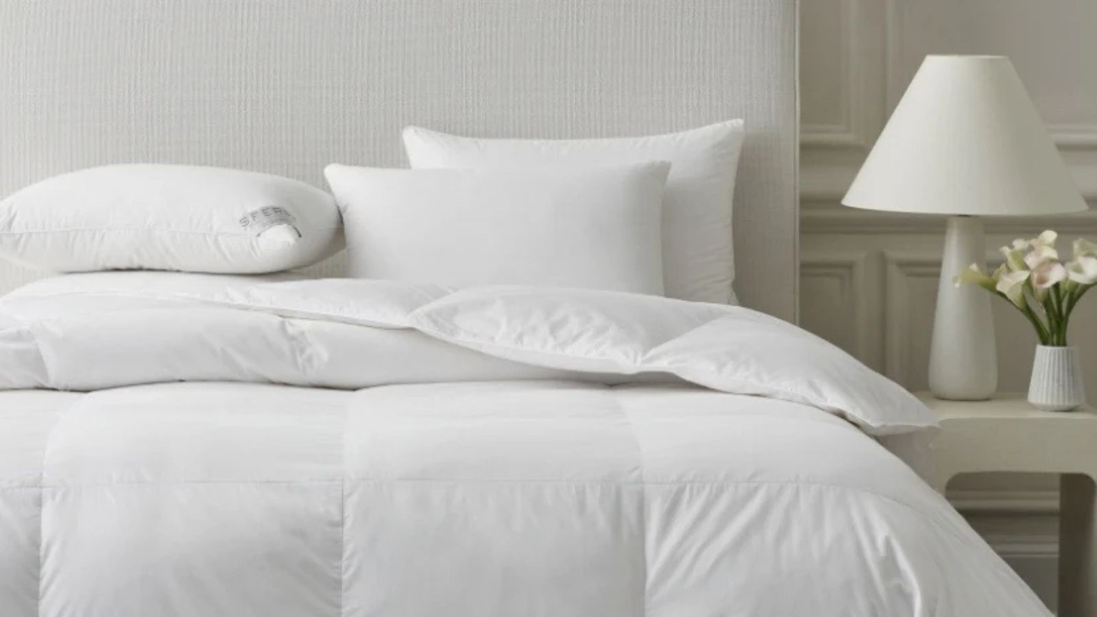 Couette Sferra Somerset sur un lit contre un mur blanc. 