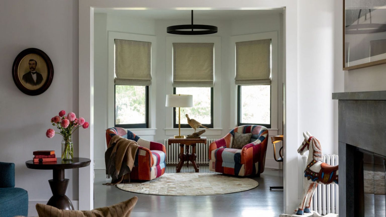 « C’était si stérile! » – La designer Jess Cooney a utilisé toutes les astuces de décoration qu’elle connaissait pour insuffler vie et personnalité dans cette maison autrefois fade Living room with bay window and colorful patchwork chairs beneath