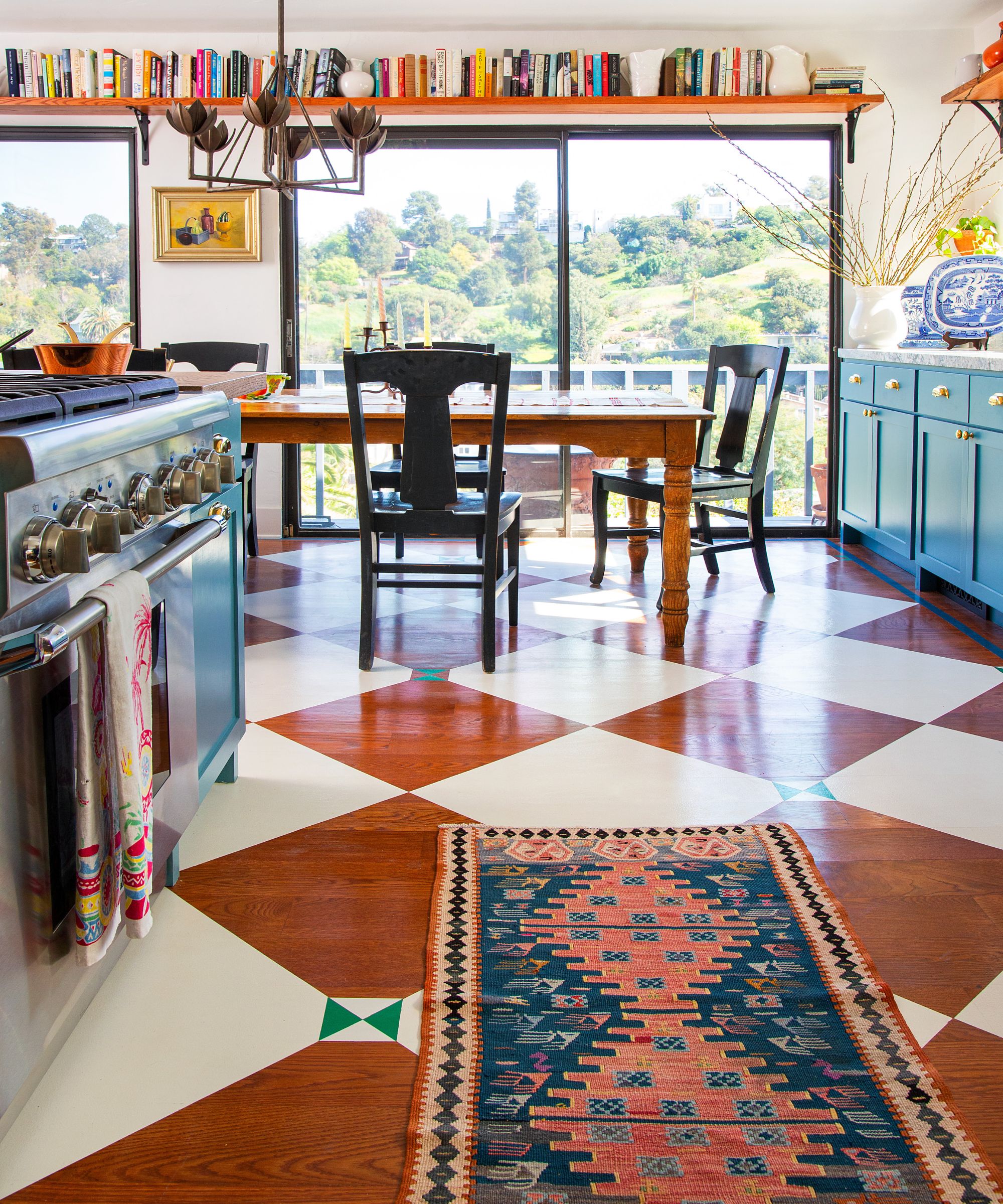 Une cuisine bleue avec du parquet peint avec un motif en damier classique