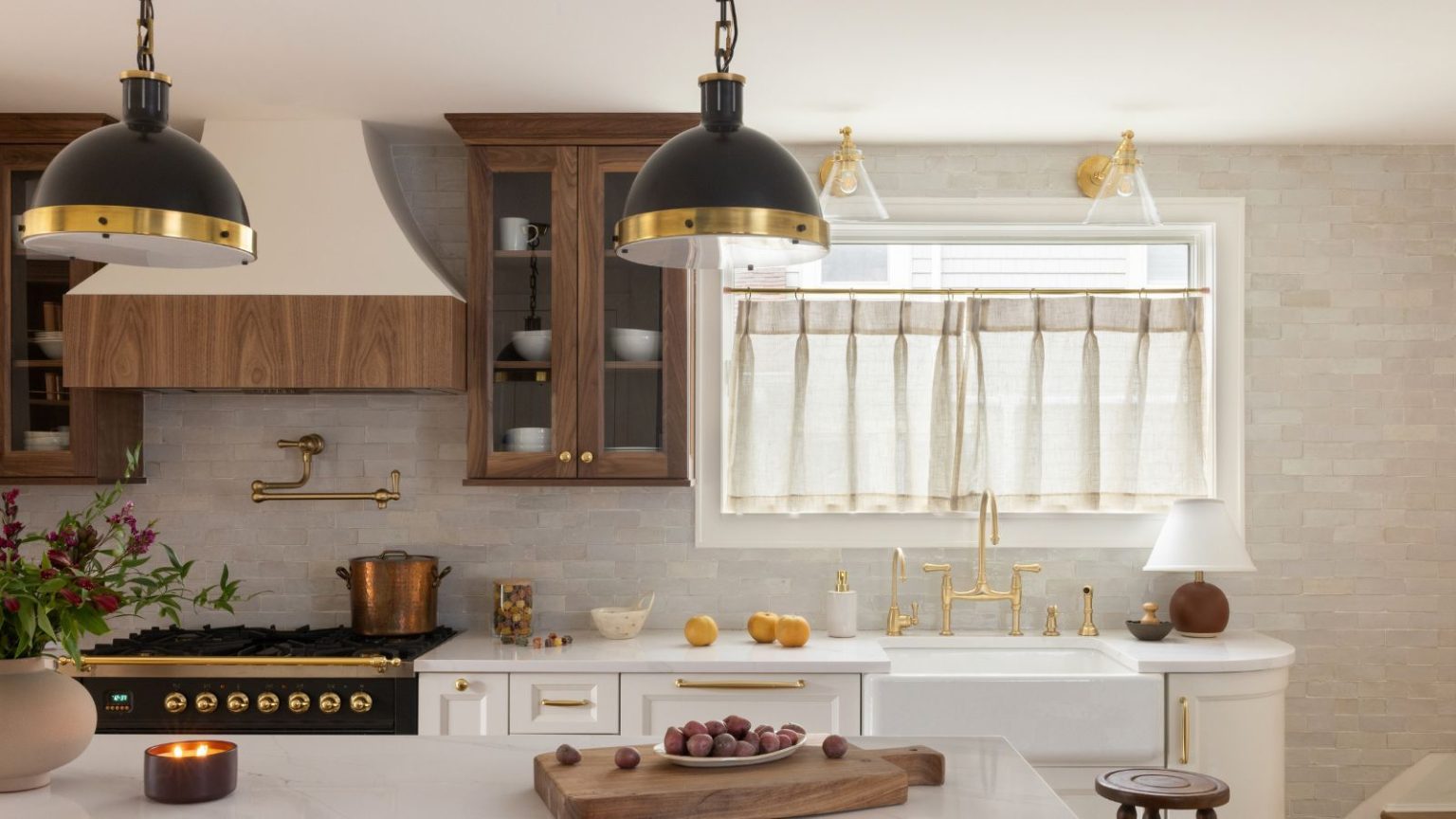 10 tendances en matière de dosserets de cuisine qui, selon les concepteurs, seront les plus évoquées en 2026 A neutral kitchen with white cabinets and cream zellige tiles on the walls