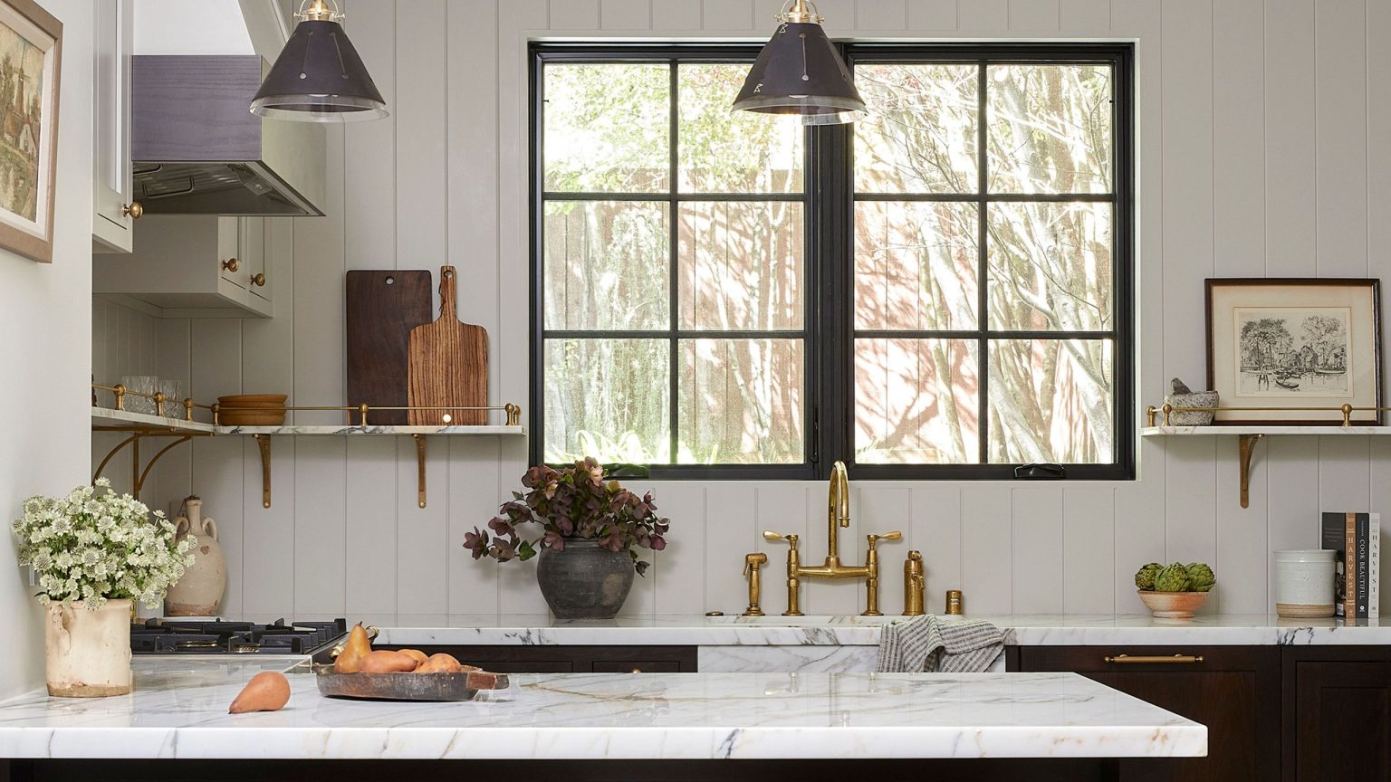 Un appartement victorien de 1895 passe du traditionnel au transitionnel avec des portes coulissantes secrètes, de la peinture noire fumée et d’anciens objets de famille White kitchen with marble top and dark cabinets
