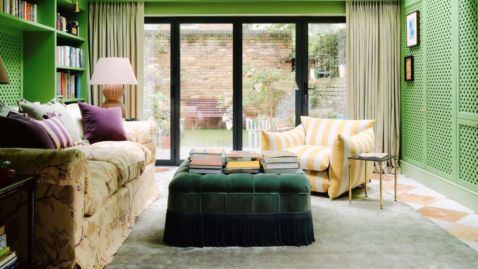 Les détails du relevé remplacent-ils les caractères gras ? Pourquoi les designers disent que vous devez essayer les franges, les passepoils et les bords contrastés en 2026 bright light green media room with white and orange terracotta marble checkerboard floor, built-in storage, floral couch, yellow striped armchair and a green velvet fringed trim ottoman