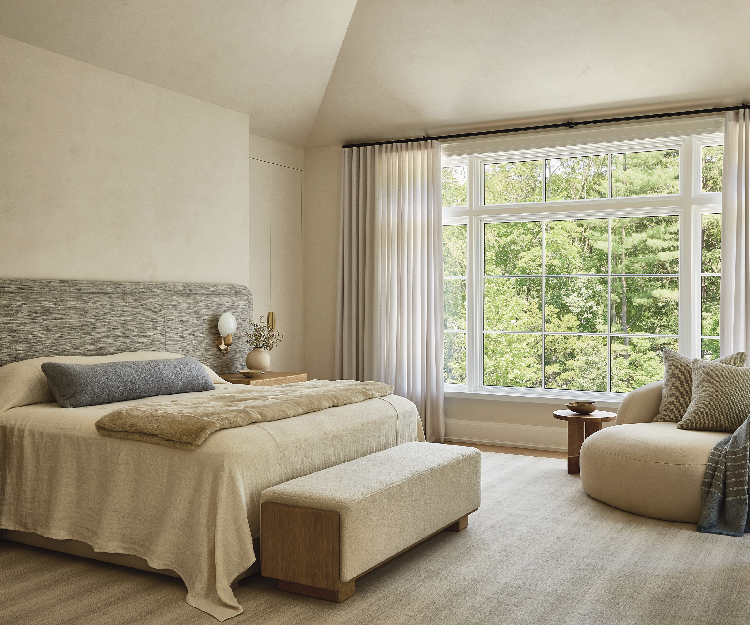 Une chambre principale aux tons ivoire avec des plafonds voûtés.