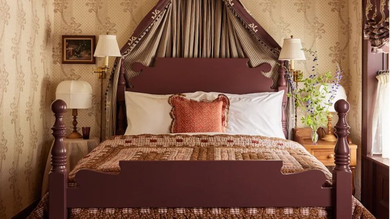 Si vous souhaitez donner à votre maison un look vintage superposé en 2026, les designers disent que c’est la couleur que vous devez utiliser The Six Bells bedroom with floral wallpaper, patchwork quilt and bed coronet
