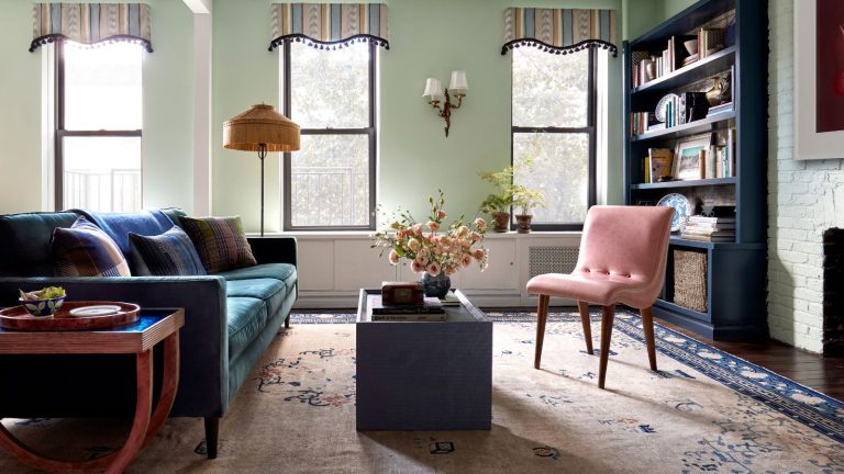 Plus besoin de couper les cheveux avec le rouleau de brosse – Cet aspirateur requin sans fil reste sans enchevêtrement et coûte 150 $ de réduction Bright pastel green living room with dark hardwood floors, pale pink and dark blue area rug, velvet blue and pink sofas and slim navy blue bookshelves