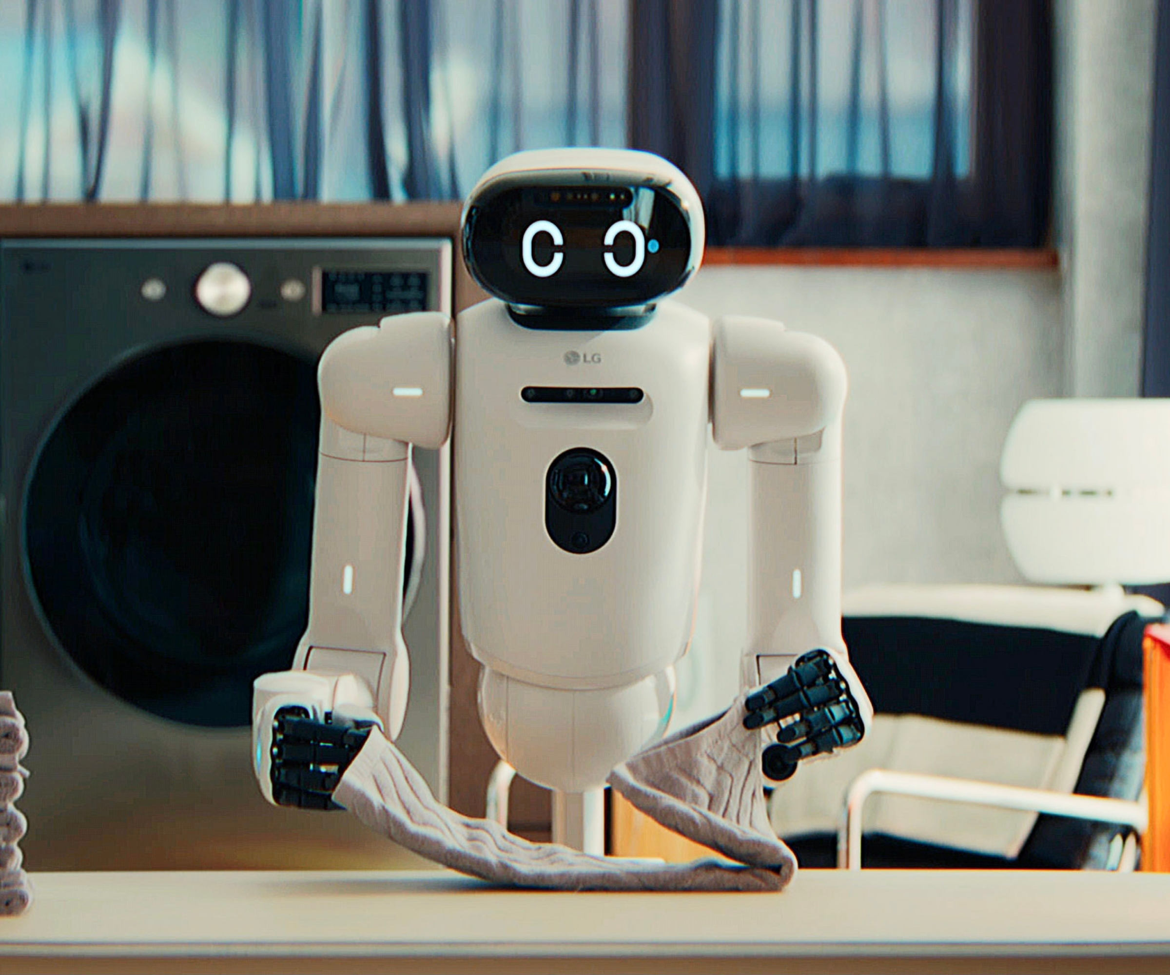 Serviette pliante du robot LG CLOiD, photographiée devant une machine à laver.