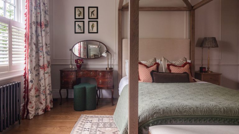 Vous réveiller avec la bouche sèche ? Les professionnels du CVC révèlent le meilleur niveau d’humidité nocturne pour votre chambre en hiver A traditional bedroom with a wooden dressing table and green stool beside a four poster bed. Wooden flooring and pink walls.