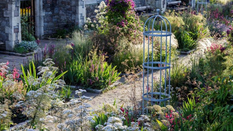 Prenez une longueur d’avance sur votre jardin de printemps – 7 travaux à faire ce mois-ci qui vous prépareront pour une bonne saison A bright and colorful garden with a paved pathway
