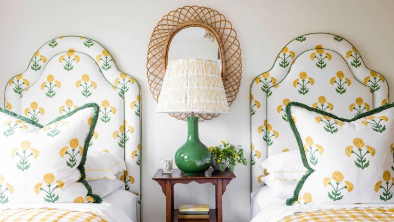 Arrêtez de respirer l’air nocif de cet élément courant de la chambre pendant que vous dormez – les experts disent de le supprimer maintenant Twin beds with matching floral bedding and headboards, with a nightstand between them featuring a tall lamp