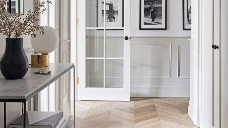 Dites adieu aux odeurs de moisi dans l’entrée avec une astuce rapide pour passer l’aspirateur – cela fait des merveilles pour les espaces étouffants A small white entryway with wooden floor boards and panelled walls