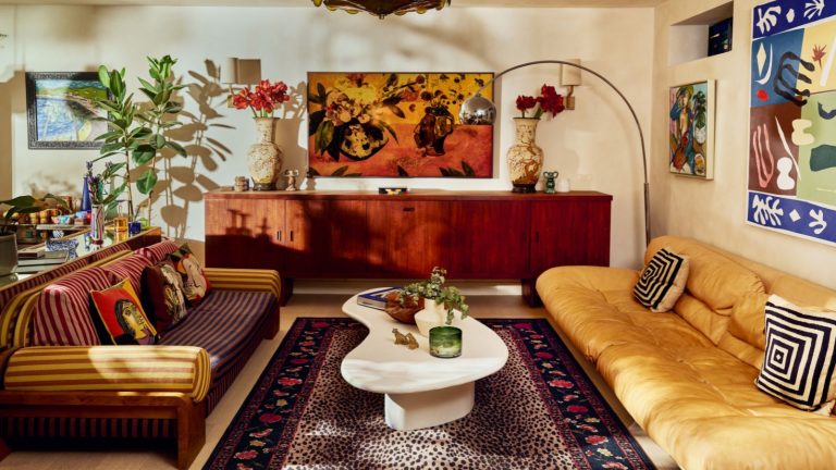 Ma marque de vêtements préférée propose désormais des tapis – Découvrez la collaboration RIXO x Ruggable qui transforme les fans de mode en casaniers neutral modern earthy living room with a large mid century credenza, 70s style low couch, white coffee table, and a leopard print rug from the rixo x ruggable collection