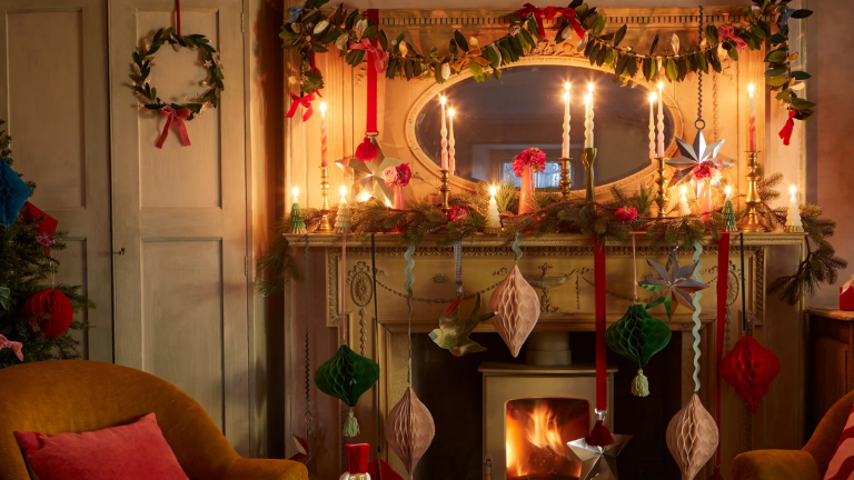 Rien ne se rapproche du charme nostalgique de la décoration de Noël en papier – Voici pourquoi vous devez introduire ce matériau ordinaire dans votre maison pour les vacances a holiday mantel decorated with various types of garland and paper Christmas decor