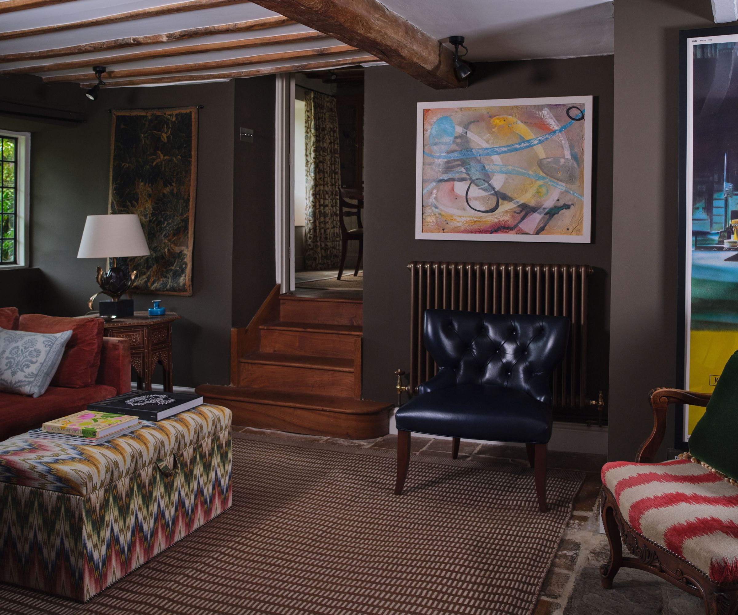 Un salon de chalet décoré de meubles anciens, de couleurs maussades et d'art moderne