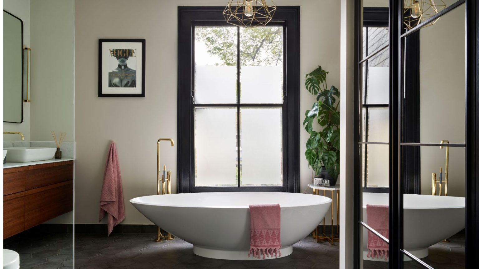 Ce porte-serviettes japonais minimaliste empêche les serviettes de sentir le moisi – et ne prend pratiquement pas de place Bright bathroom with freestanding tub and large windows and mirrors, gold hardware and wooden undersink vanity
