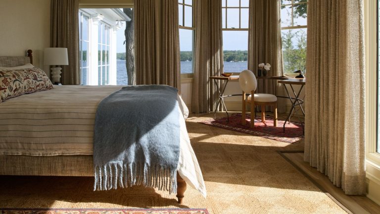 Le bleu poudré est la tendance de couleur inattendue pour l’automne – voici comment utiliser cette teinte fraîche et apaisante dans toute votre maison A bedroom with a neutral color scheme and large windows with a powder blue throw on the bed.