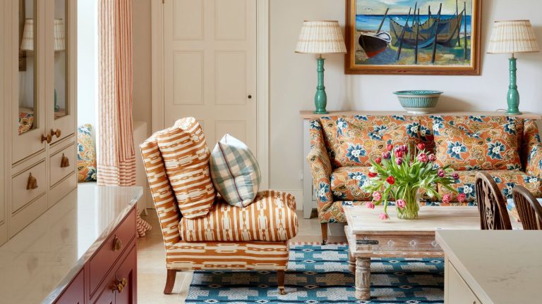 Voici tout ce que mon constructeur m’a dit de NE PAS faire lors de la rénovation de ma maison et pourquoi je suis heureux de les avoir ignorés neutral snug at the end of a cozy kitchen by Yellow London with and orange floral couch and a blue folk weave rug