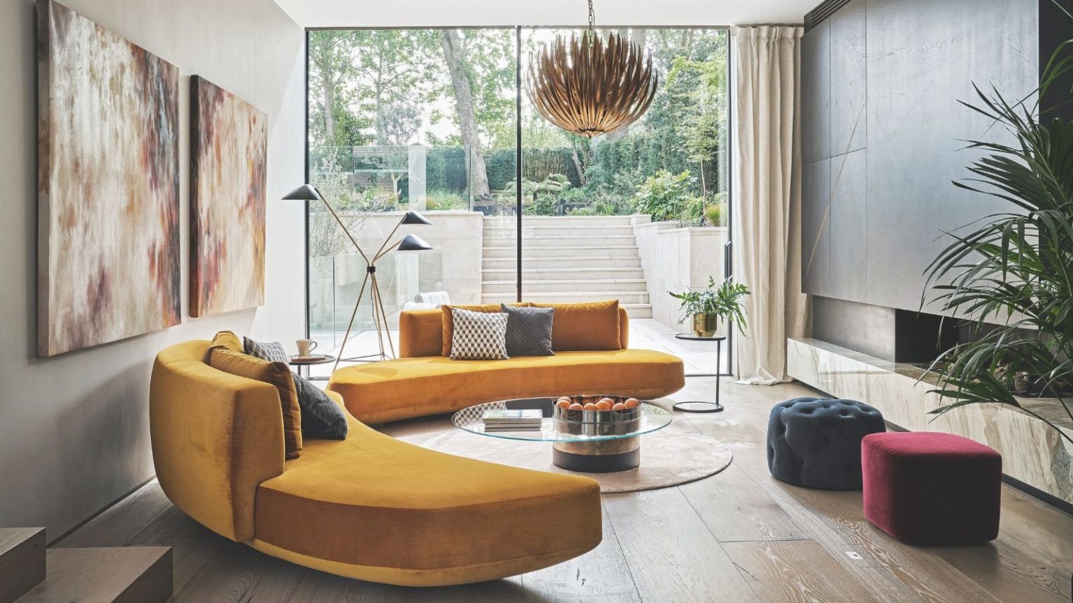 Bannissez les odeurs hivernales fades en quelques minutes avec ce purificateur d’air compact Coway – il a éliminé les odeurs si rapidement pendant nos tests et est maintenant à 60 $ de réduction Living room with orange semi circular sofa on wooden floor, glass walls out to patio and garden.