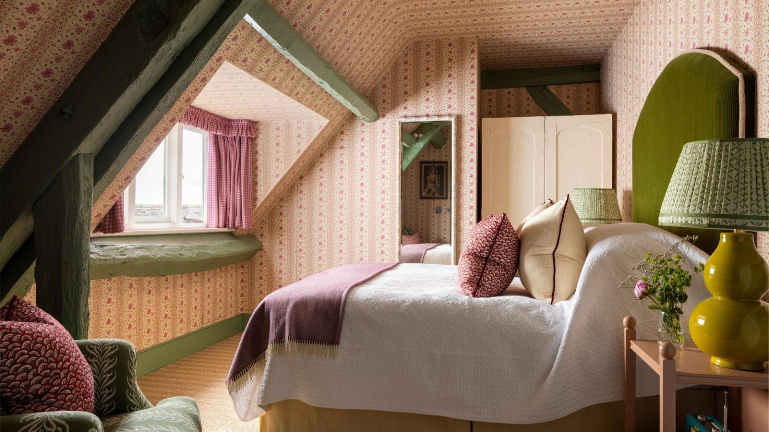 5 clichés de couleurs courants qui pourraient freiner le style de votre maison – Les designers révèlent les règles à ignorer en 2026 A cozy, traditional bedroom with pink and green decor.