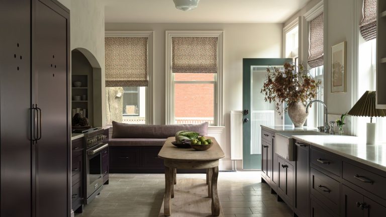 A white and burgundy kitchen with cabinet cutout details