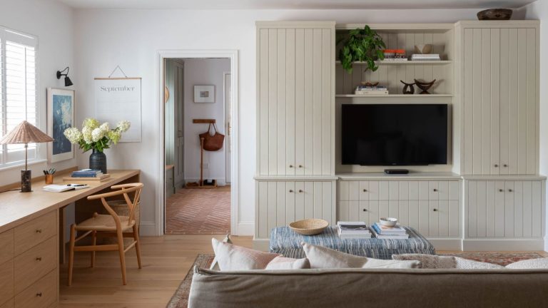 Utiliser une liste « Plus/Moins » est le secret pour garder votre maison bien rangée sans culpabilité ni perte de motivation, révèlent les organisateurs professionnels A living room with a long built-in desk along one wall, and a built in media unit on the adjacent.