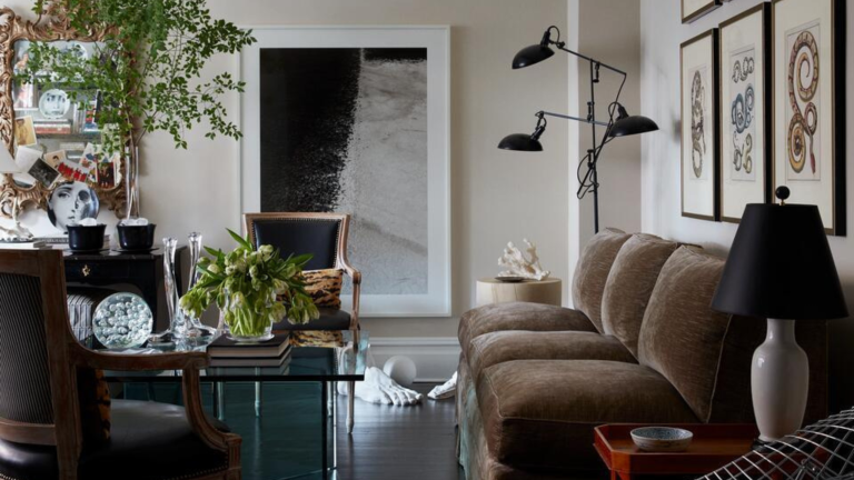 small living room with cream walls, a brown velvet sofa, large prints and a glass dining table