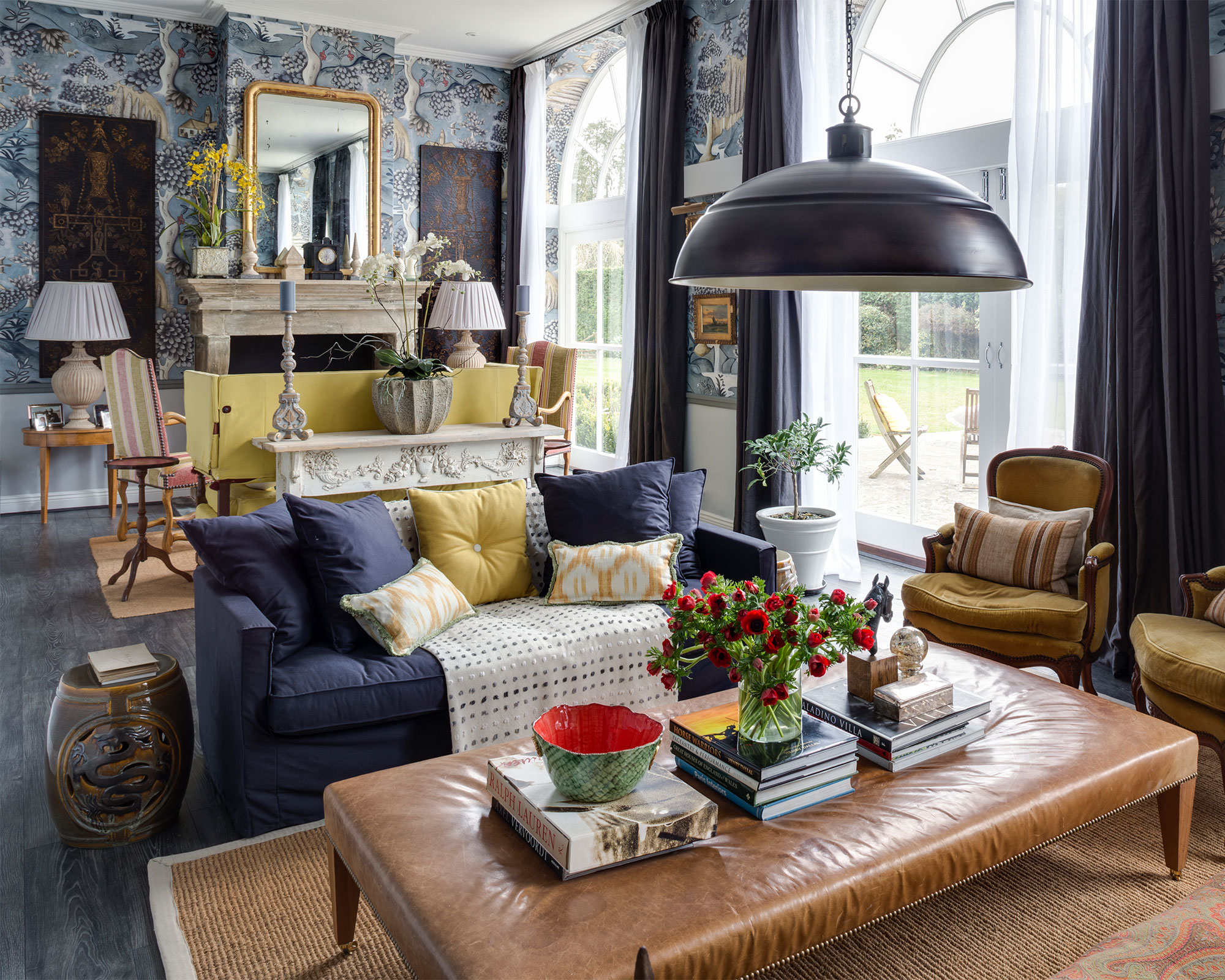 Une variété d'idées d'éclairage pour petits salons dans un schéma bleu et jaune avec du papier peint tendance et de grandes portes-fenêtres.