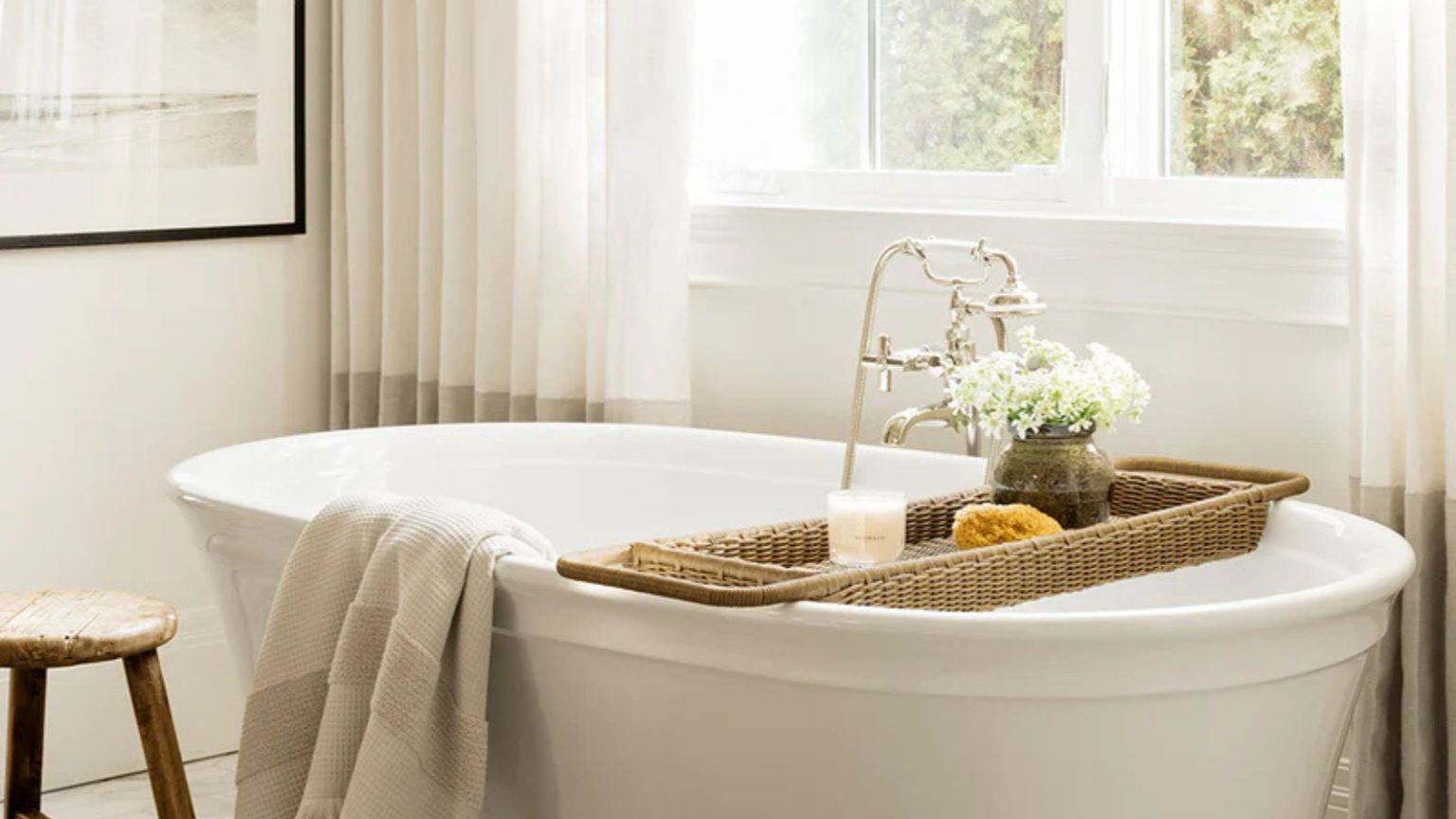 J’en avais assez de voir mon panier de bain en bois moisir en quelques mois seulement, mais je viens de le remplacer par ce design chic et résistant à la moisissure en rotin de McGee & Co. A white freestanding bath tub styles with a rattan bath caddy