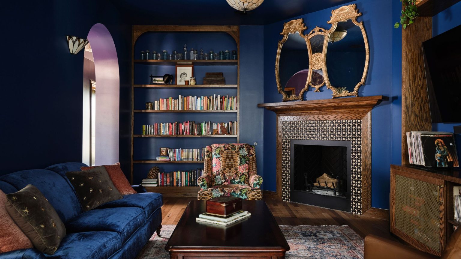 dark blue living room with wood fireplace and dark blue sofa