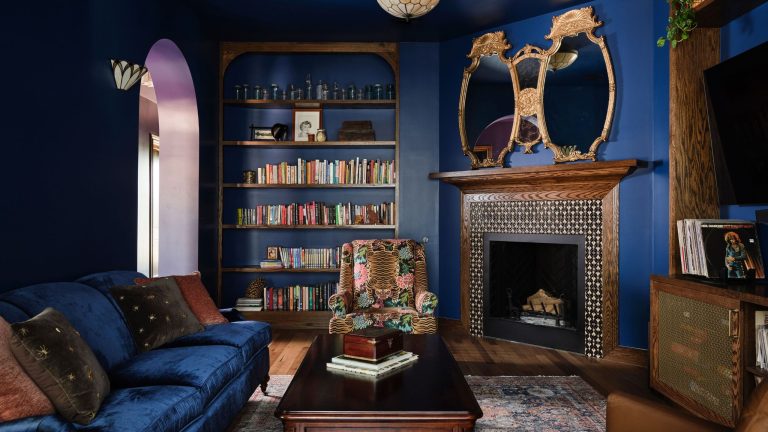 dark blue living room with wood fireplace and dark blue sofa