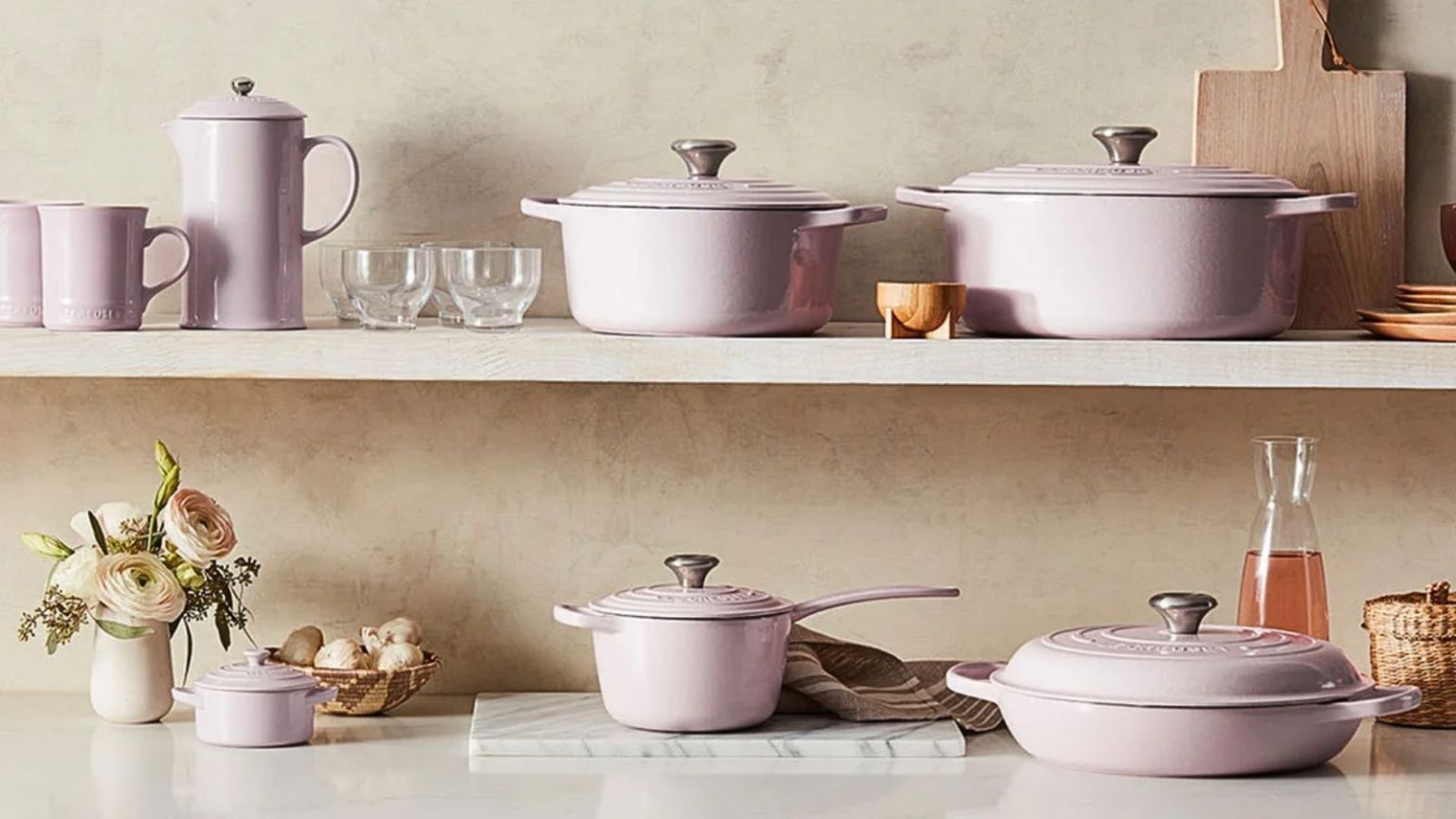 Les rumeurs sont vraies : Le Creuset retire deux couleurs « préférées des fans » – et nous avons trouvé les dernières pièces encore en stock The complete Le Creuset Shallot set of pans and lids across a countertop and shelf.