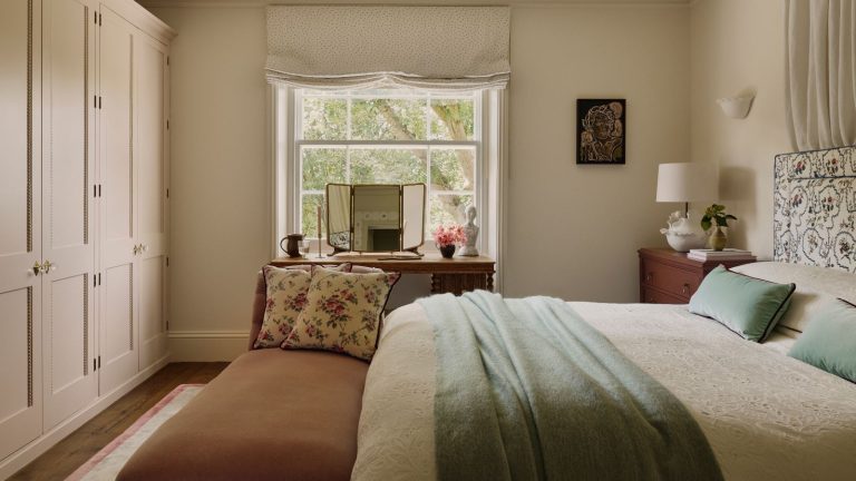 Vous ignorez l’endroit le plus sous-utilisé de votre chambre – Les designers disent de mettre ceci, ceci ou ceci au pied de votre lit pour plus de style et de rangement. neutral london bedroom designed by Emma Ainscough with a wall of wardrobes and a canopy bed
