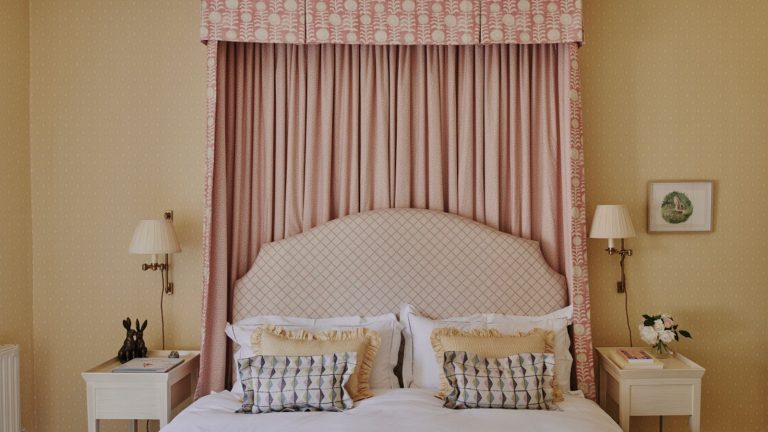 L’édition très britannique : des teintes sombres d’hiver aux tons printaniers doux – Comment je rends ma chambre plus claire, plus lumineuse et complètement accueillante Spring bedroom with yellow pastel walls, bed canopy, printed headboard, wall sconces and yellow frilly cushions