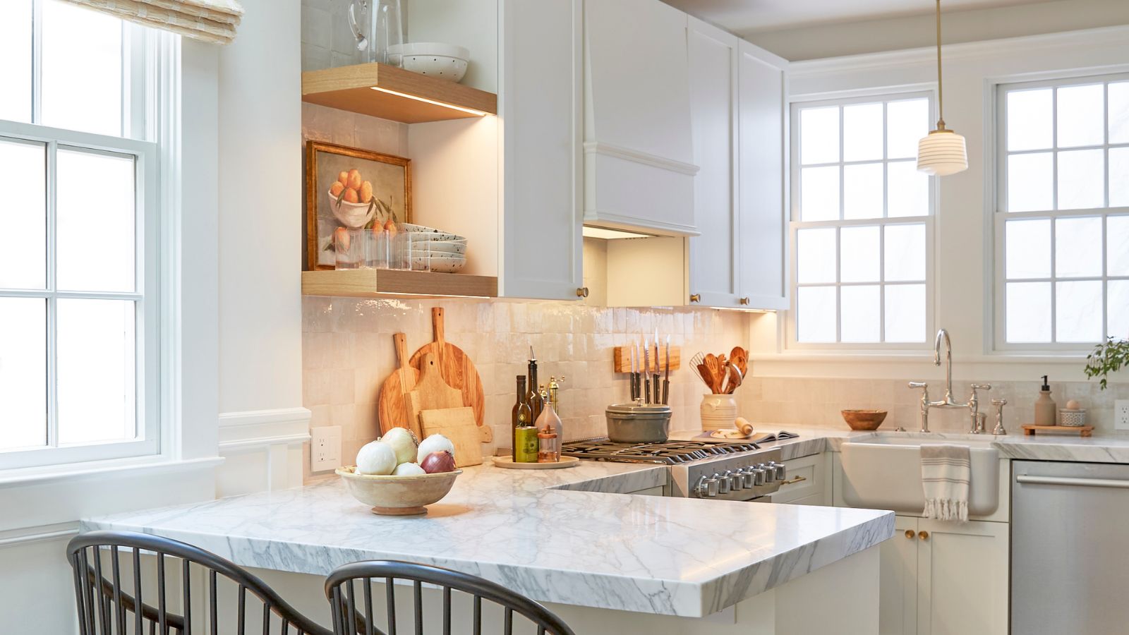 Une petite cuisine péninsule blanche avec comptoirs en marbre et déco en bois