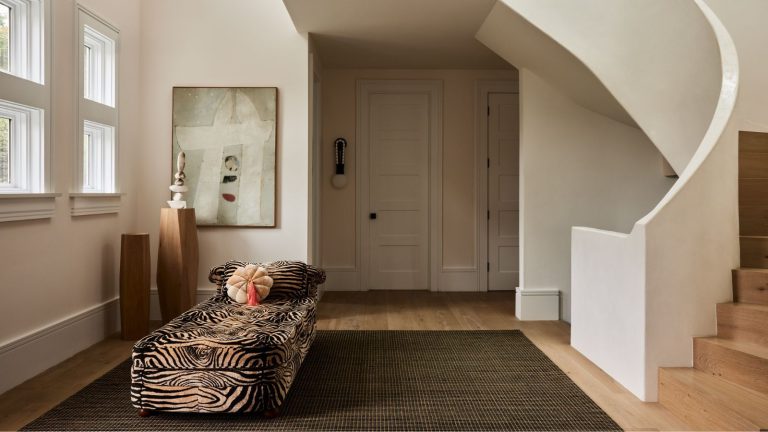 Les lits de repos remplacent-ils les canapés ? Les designers révèlent quand échanger – et quand votre canapé gagne Entryway with spiral staircase, large olive green rug on wooden floor, tiger print daybed with velvet pink cushion and modern abstract painting in the background