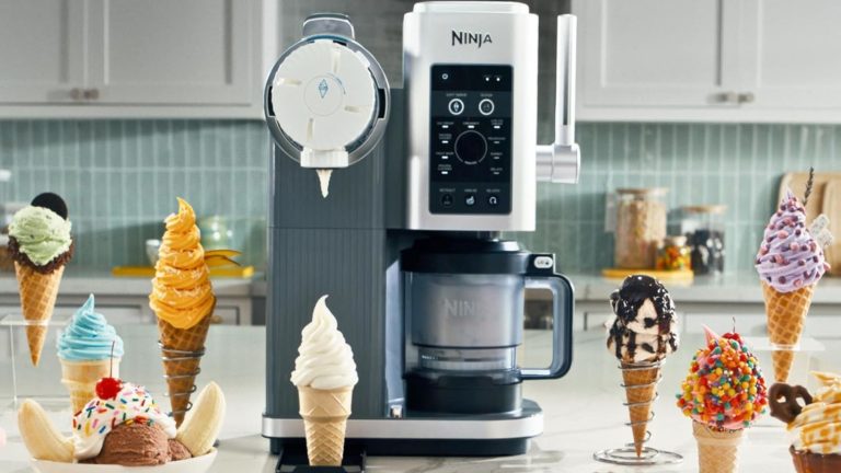 A Ninja&reg; CREAMi&reg; Scoop &amp; Swirl on a kitchen counter surrounded by swirled ice cream in cones.
