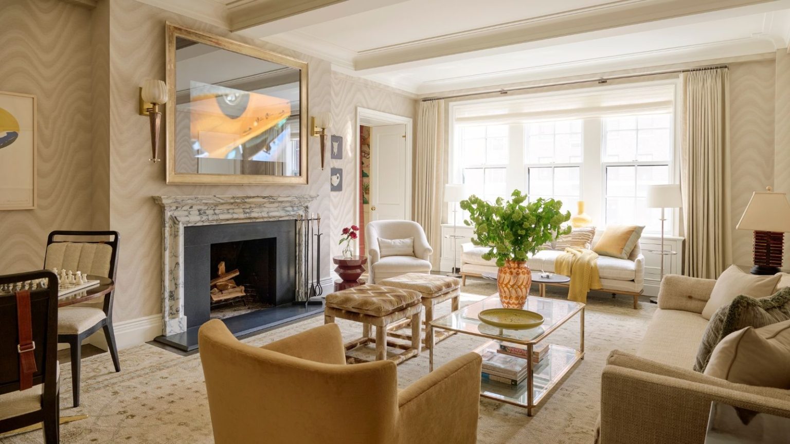 Je réduis ma facture d’électricité sans rien débrancher – voici l’astuce à 6 $ que j’utilise tous les soirs Bright living room with beige and cream interior, TV mounted on wall, sofas, armchairs, and a window bringing in daylight.