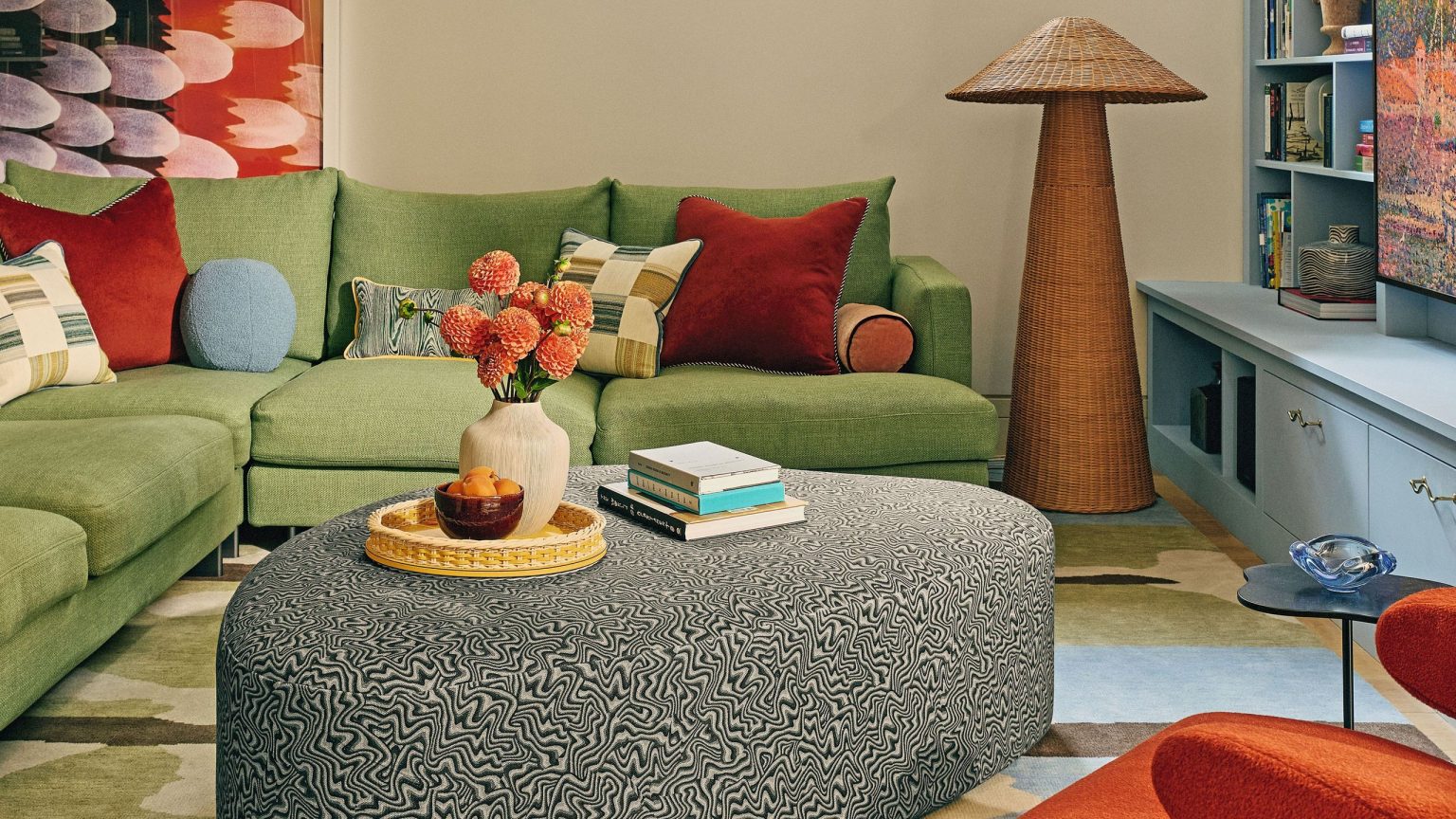 24 trouvailles sophistiquées pour une maison colorée, sculpturale et pleine d’âme – parfaite pour tous ceux qui s’ennuient des intérieurs entièrement blancs Colorful seating room area featuring a painterly rug, swirl-upholstered irregularly shaped ottoman, and a woven floor lamp