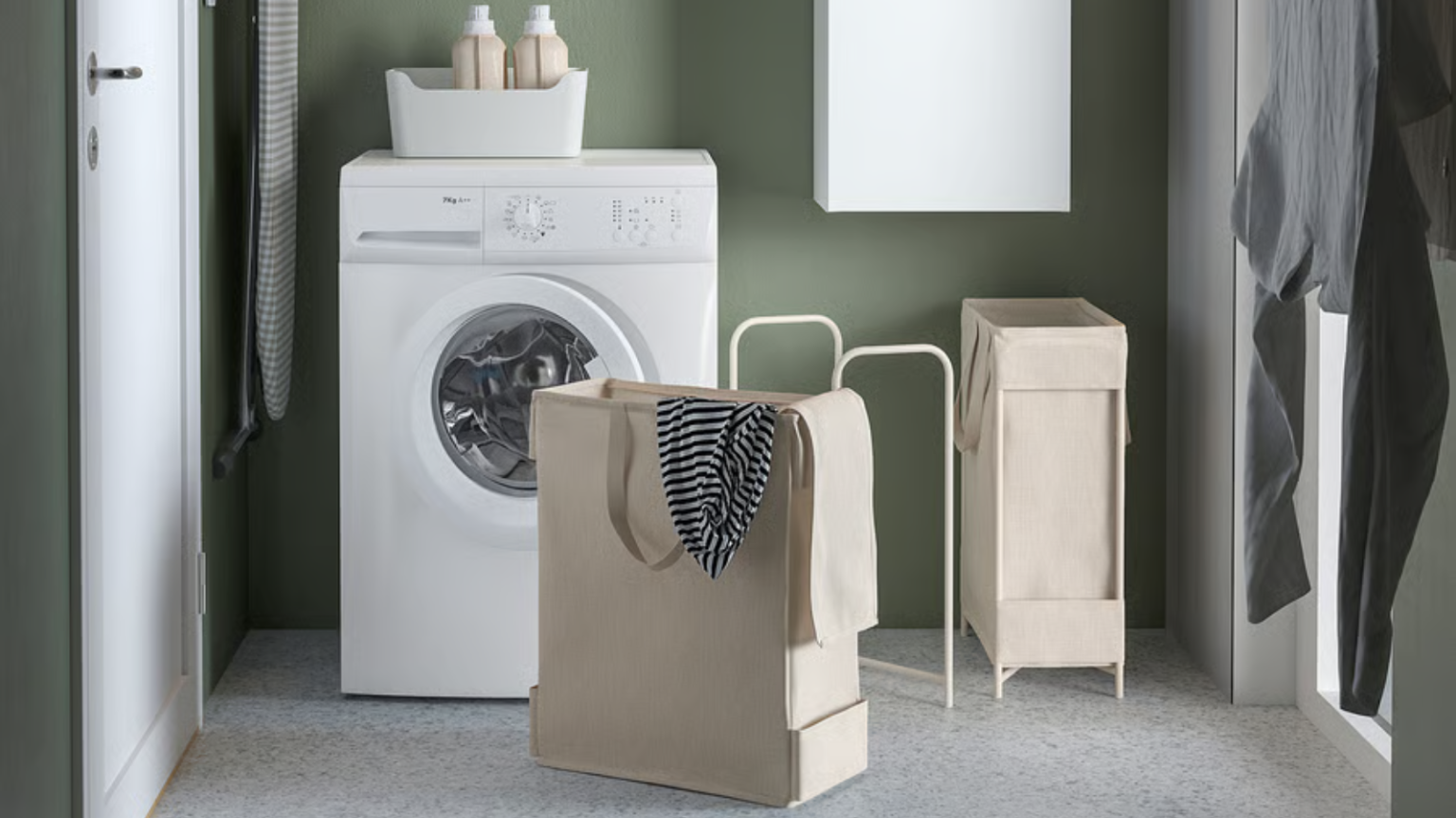 Faire la lessive dans un petit walk-up de New York était un cauchemar – jusqu’à ce que je trouve ce petit bijou IKEA à 25 $ a laundry room with a white washer machine and a tan laundry basket