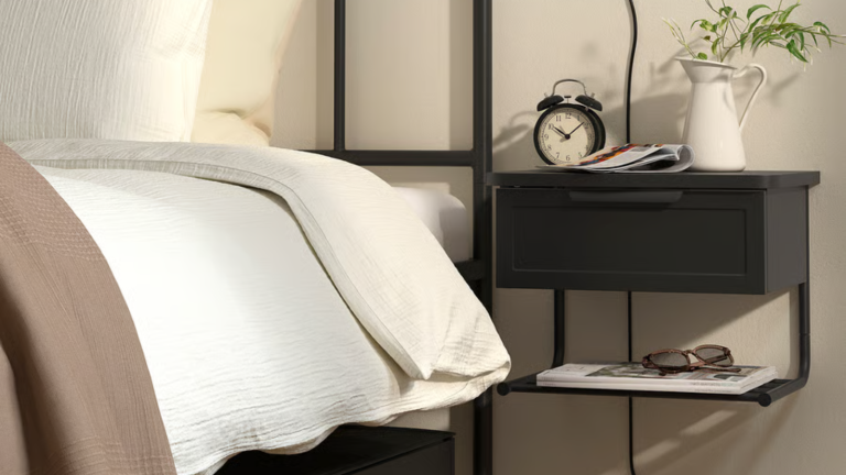 Je pensais que mon studio de New York était trop petit pour une table de chevet – jusqu’à ce que je trouve cette solution IKEA murale astucieuse a black wall mounted nightstand next to a bed from IKEA