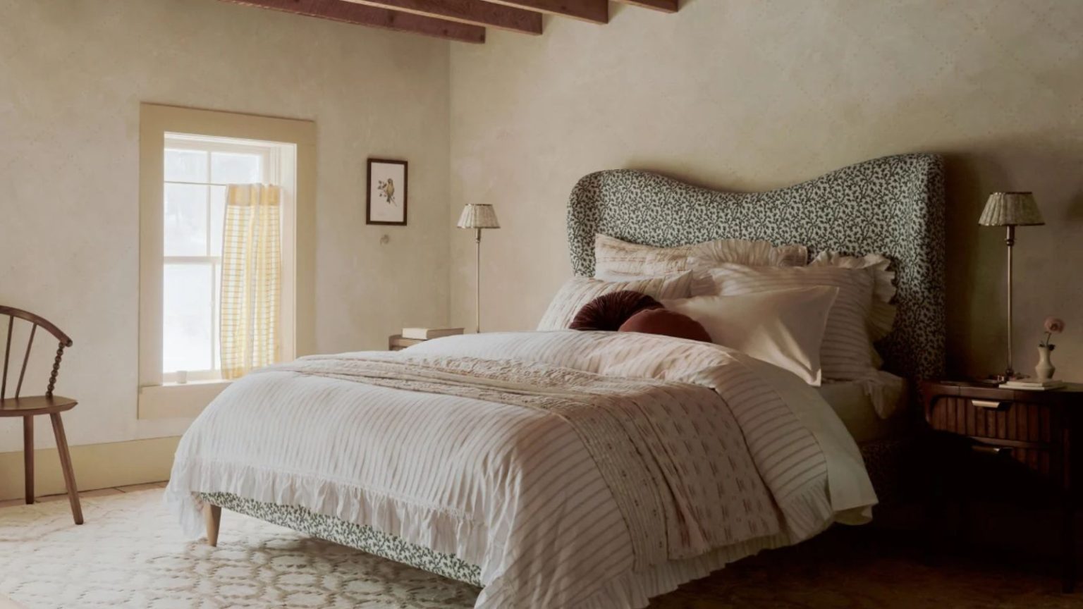 Les concepteurs d’échange de couleurs en 10 minutes utilisent pour égayer instantanément une chambre pour le printemps – et non, cela n’implique pas de pinceau Muted spring bedroom, large bed with patterned headboard, pink bedding, two tall table lamps on wicker bedside tables