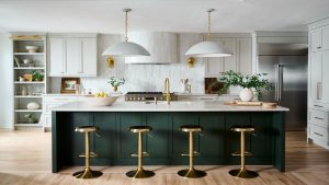Les designers disent que cette tendance des hottes de cuisine est le secret d’une cuisine unique, luxueuse et absolument chic en 2026 A large kitchen with white cabinets, a green island, and a white zellige backsplash and matching tiled range hood