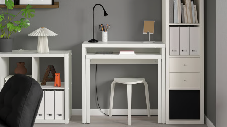 a room with a white desk, a white bookshelf, and a small white console table