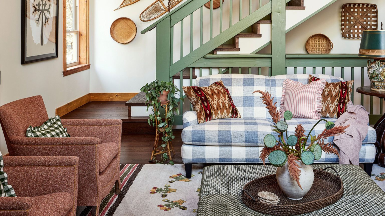 Les créateurs reviennent sans cesse à Vichy – 20 pièces chics à styliser pour le printemps et l’été 2026 Rustic great room featuring an eclectic mix of wall art, collected objects, and upholstered furniture – the gingham loveseat being the most statement-making of the bunch
