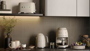 La couleur SMEG de l’année est loin de ses teintes rétro audacieuses habituelles – voici pourquoi c’est le choix parfait pour nos cuisines en 2026 A set of matte cream colored SMEG appliances on a black kitchen counter