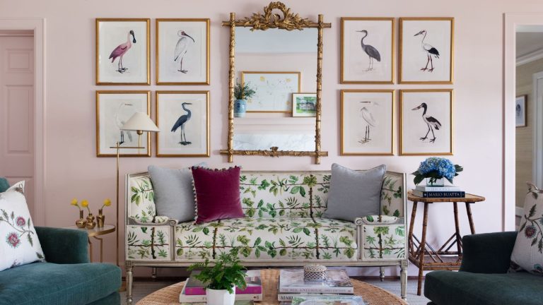 spring living room ideas 2025 pink painted living room with a floral sofa and a large antique mirror with gallery wall of vintage art