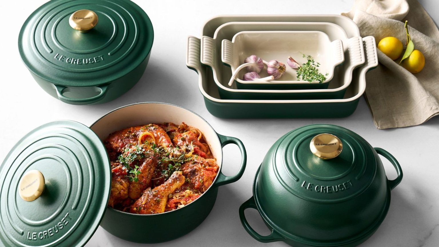 Si vous n’achetez qu’une seule pièce Le Creuset, faites-en celle-ci – c’est 170 $ de réduction en ce moment The Le Creuset enameled cast iron collection in deep Foret green, on a marble counter.