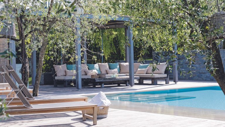Ce banc de rangement de jardin 2-en-1 inspiré de Nancy Meyers est la mise à niveau chic mais pratique dont votre petit patio a vraiment besoin Outdoor space with pool and seating