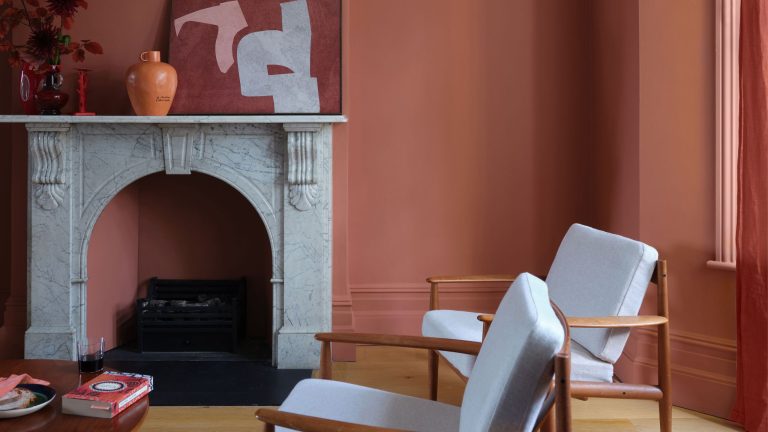 Terracotta living room featuring an ornate stone fireplace and mid-century-style furniture